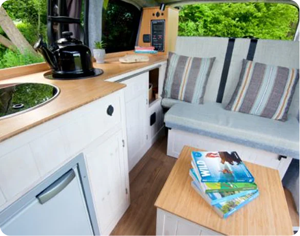 Campervan kitchen with hob, kettle and striped seat cushions