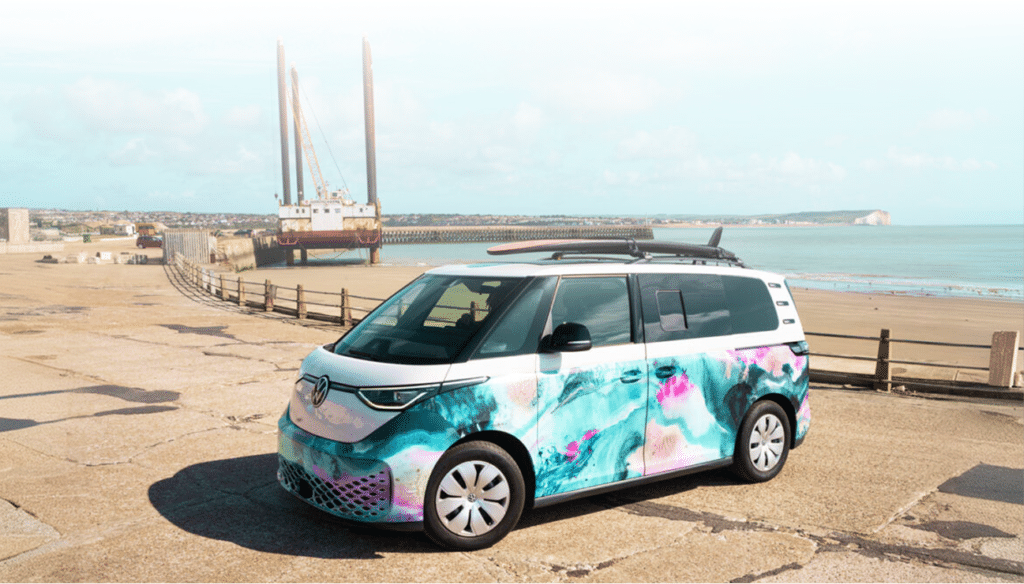 VW ID. Buzz with colourful wrap parked by the harbour