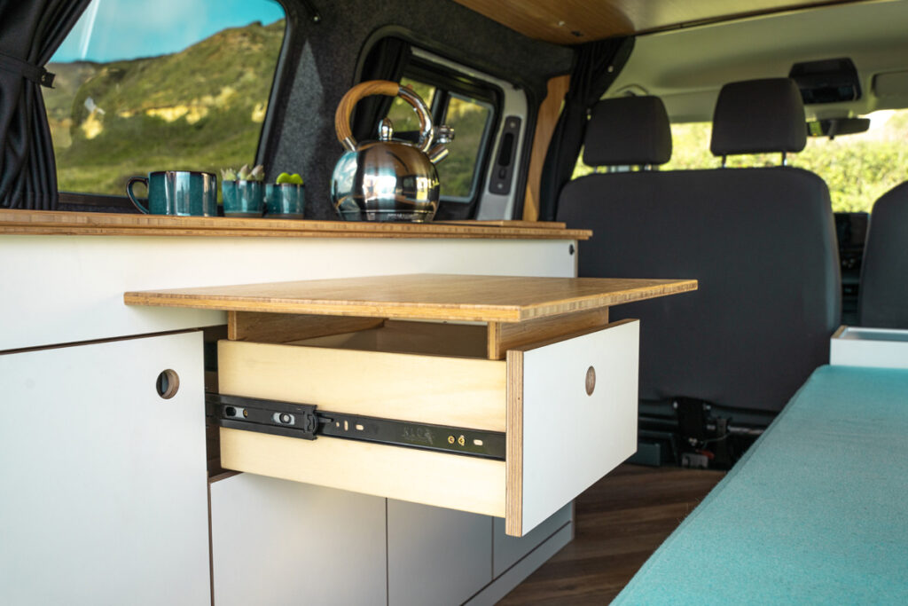 Campervan cupboard opened to reveal additional worktop space