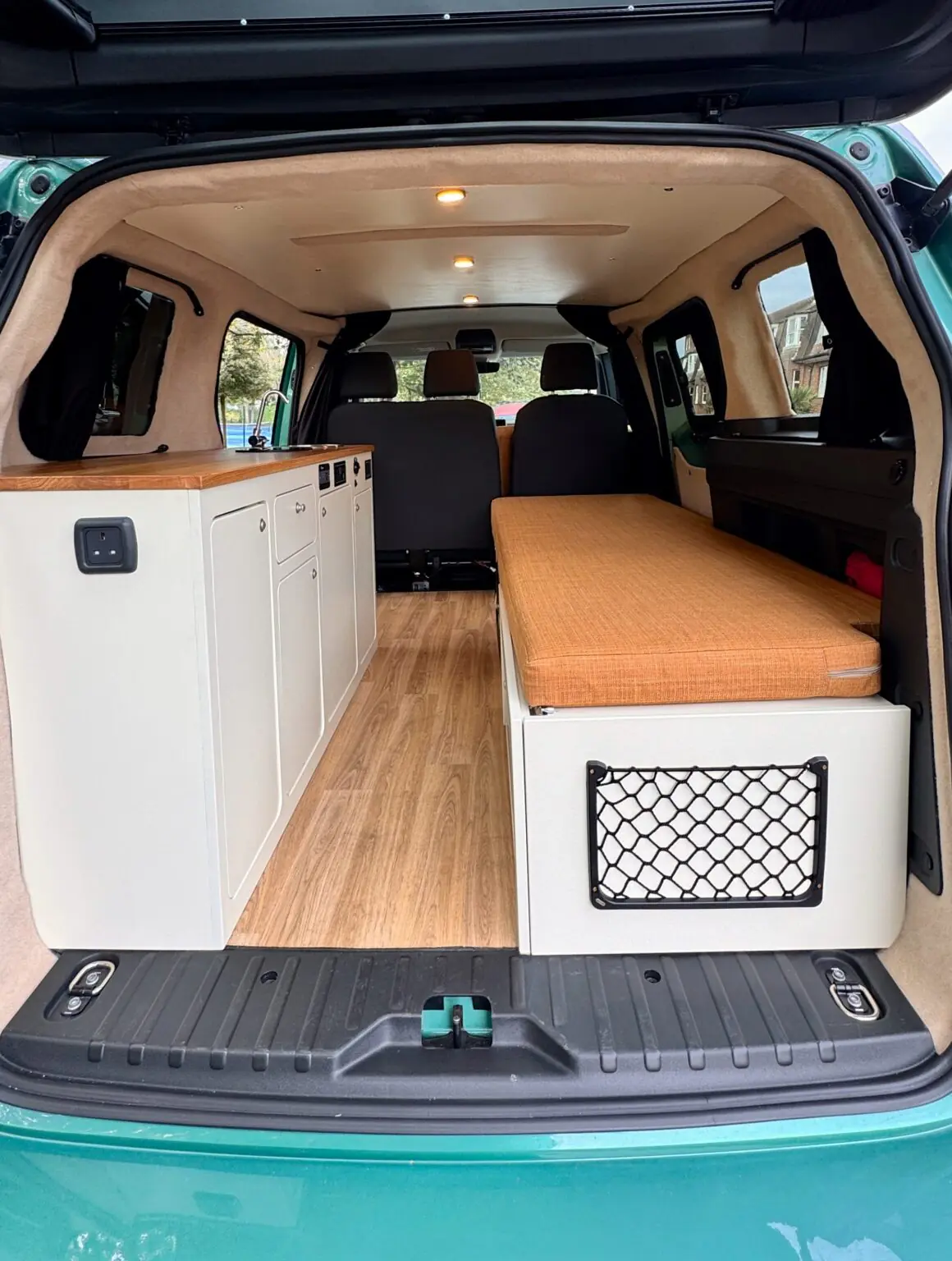 VW ID. Buzz campervan interior with white units and wooden floor